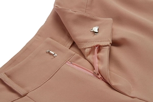 Close-up of waist closure with silver hook and zip on pink formal trousers
