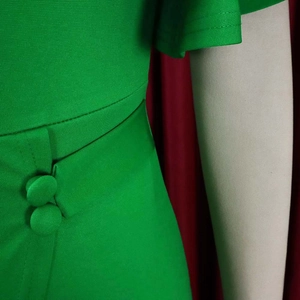 Detail of green dress featuring twill texture fabric and elegant fabric-covered buttons