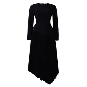 Detail of elegant black dress showing asymmetrical neckline and pleated irregular hemline
