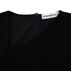 Detail of elegant black off-shoulder dress featuring a hidden back zipper and smooth texture