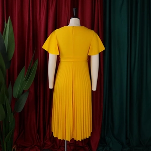 Detail view of the fine accordion pleats and waist tie on the yellow V-neck midi dress
