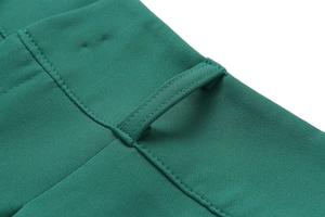 Detail of high-waisted dark green trousers showing precise belt loops and stitching