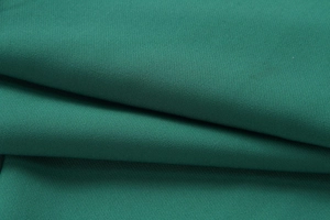 Detailed close-up of dark green woven fabric showing premium texture and fiber weave