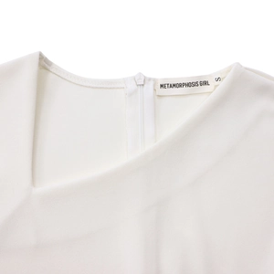 Detail of elegant asymmetric neckline and brand label on white mid-length dress