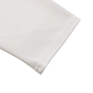 Detailed close-up of double-stitched sleeve cuffs on an elegant white cotton dress