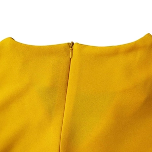 Close-up of invisible zipper and textured bright yellow fabric on back of a V-neck dress