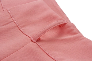 Detail view of pink trousers showing the belt loop reinforced stitching and woven fabric