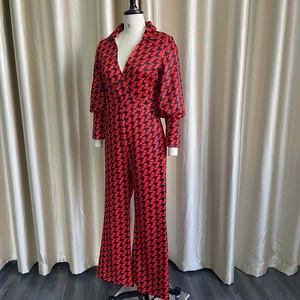 Detail of V-neck houndstooth jumpsuit with long sleeves and tailored waist on mannequin