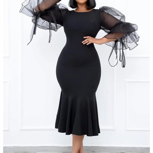 Detail of sheer mesh puff sleeves with long ribbons on a black fishtail dress