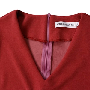 Detail view of the V-neckline and back hidden zipper on the dark red pleated dress
