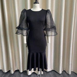 Detail of sheer puff mesh sleeves and elegant fishtail hem on a black evening dress