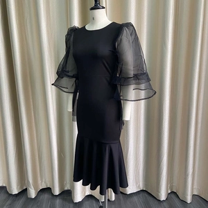 Detail of elegant black bodycon dress with sheer mesh puff sleeves and ruffled cuffs