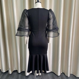 Detail view of the elegant mesh bubble sleeves and back zipper of the black fishtail dress