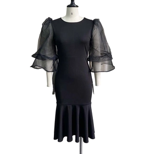 Detail of layered black organza mesh puff sleeves on a fishtail midi evening dress