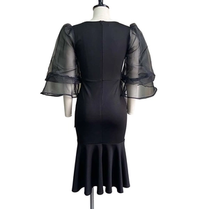 Detail of sheer organza puff sleeves and mermaid hem on a black bodycon midi dress