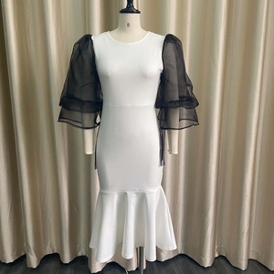 Detail of sheer black mesh puff sleeves with ruffled layers on a fishtail dress