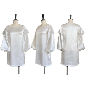 Detail view of the elegant white satin dress with puff sleeves and ruffle shoulder accents