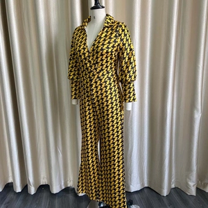Macro detail of yellow houndstooth jumpsuit with deep V-neck and puff sleeve design