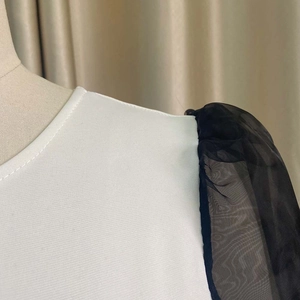 Detail of puff sleeves with black mesh and precise stitching on a fishtail dress