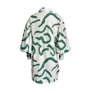 Detail view of the green abstract print and puff sleeves on this white shirt dress