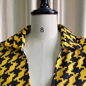 Detail of yellow and black houndstooth pattern fabric with classic collar and texture