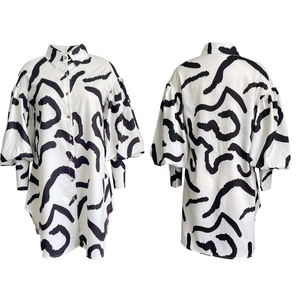 Detail view of abstract black and white print shirt dress with lapel and long sleeves
