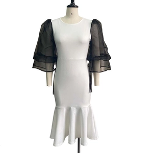Detail of elegant black mesh lantern sleeves and fish tail hem on a color-block dress