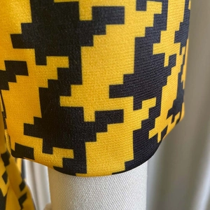 Macro shot of yellow and black houndstooth pattern fabric with detailed knit texture
