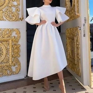 Detalle del vestido blanco de cuello alto con mangas de volantes dramáticos y corte evasé