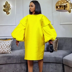 Modern bright yellow puff sleeve satin dress with loose fit and elegant knee-length silhouette