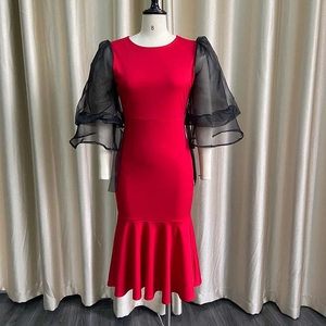 Detail of red bodycon dress featuring layered black organza puff sleeves and knit texture