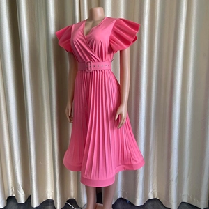 Détail de la robe rose plissée à col en V avec manches volantées et ceinture assortie