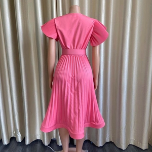 Détail de la robe rose plissée à col en V avec manches volantées et ceinture à nouer