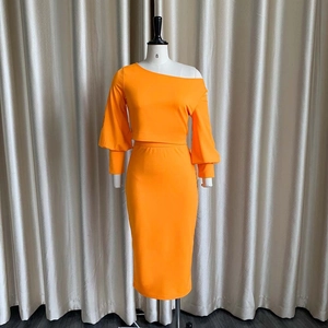 Detalle del conjunto de dos piezas naranja con top de hombros caídos y falda de tubo midi