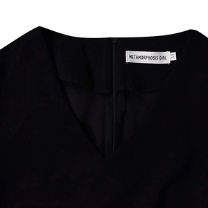Detail of V-neckline with invisible back zipper and brand label on black dress