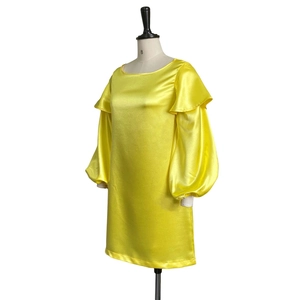 Detail of bright yellow satin dress showing ruffled shoulders and elegant puff sleeves