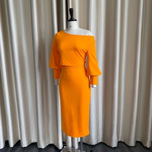 Vista de detalle del conjunto de dos piezas naranja brillante con top sin hombros y falda