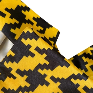 Macro detail of high-waisted wide-leg jumpsuit with yellow and black houndstooth print