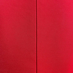 Detail of red mesh fabric stitching with fine knitted texture on a fishtail dress