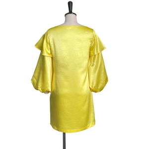 Rear view of yellow satin mini dress with voluminous puff sleeves and ruffled details