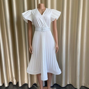 Détail de la robe plissée blanche avec col en V, manches volantées et ceinture assortie