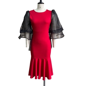 Detail of red fishtail dress with contrasting black mesh layered lantern sleeves