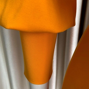Detalle de la textura de punto naranja y los puños elásticos acanalados del conjunto