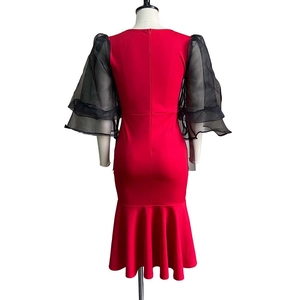 Detail of red mermaid dress showing black double-layered mesh puff sleeves and back zipper