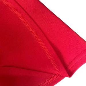 Close-up of zigzag stitching on red mesh fabric for high-quality dress detail