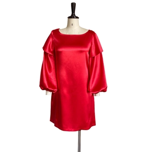 Close-up of bright red satin dress with ruffle shoulders and puffy lantern sleeves