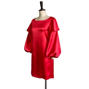 Detail view of red satin dress featuring elegant ruffled shoulders and lantern sleeves
