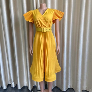Détail d'une robe jaune plissée à col en V, manches volantées et ceinture