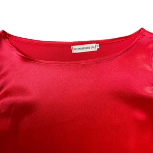 Close-up of red satin dress neckline showing METAMORPHOSIS GIRL brand label and size M