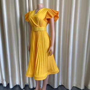 Détail d'une robe midi jaune à col en V avec texture plissée et volants